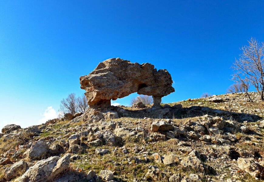 A rock formation on top of a rocky hill.