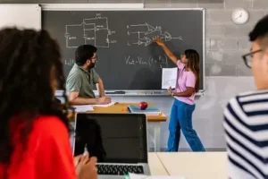 A group of people in front of a blackboard in a classroom.